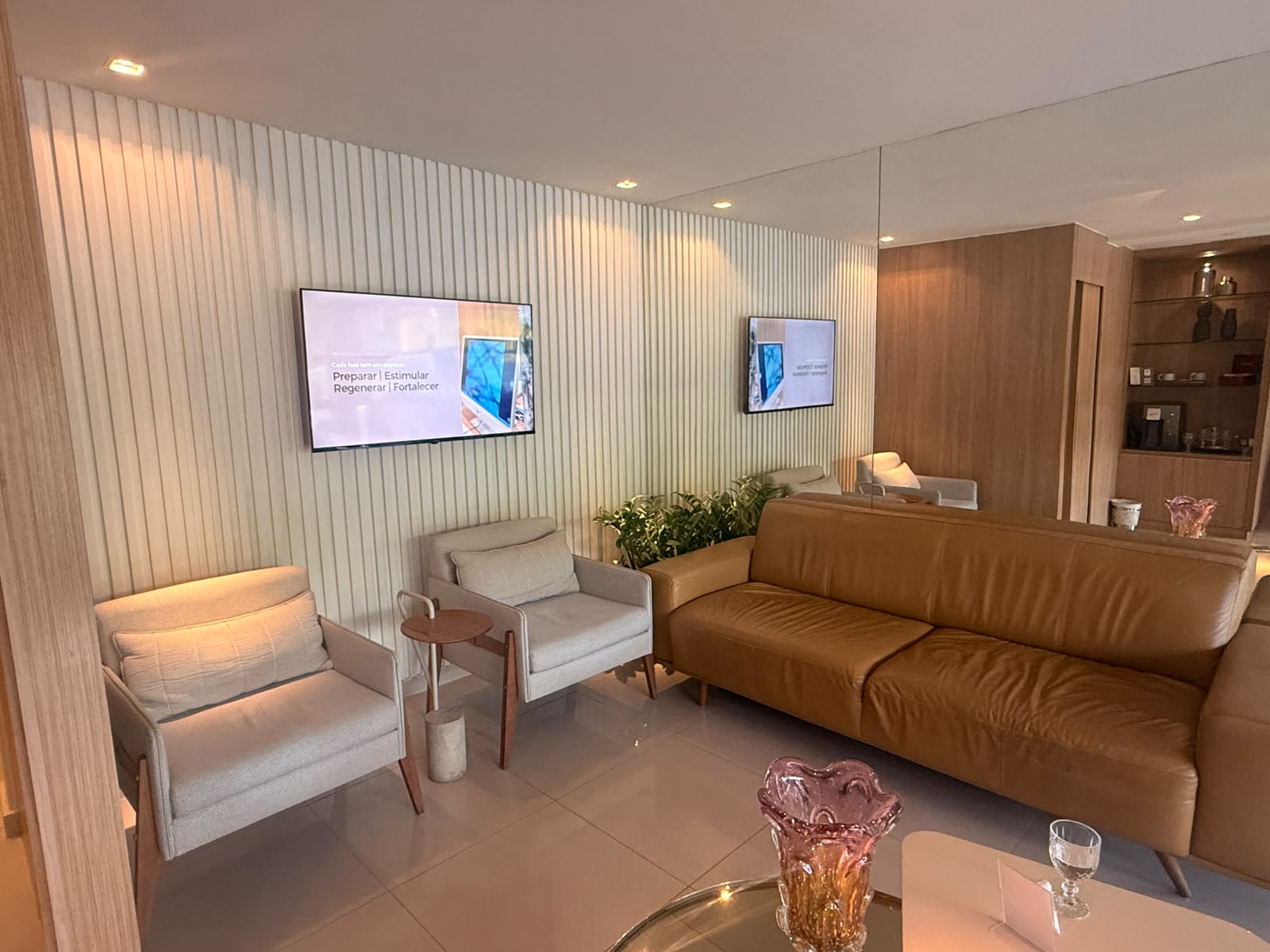 Sala de espera da Clínica Caiena com poltronas e sofá de couro